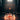 Centered low-angle view of the LA Pipes "Phoenix Rising" Color Wrapped Beaker Bong surrounded by a ring of flames on a dim wooden floor.