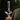 A hand-held side view of the clear DankStop Fumed Zong Bong - 15 in. showcasing its twisted S-shaped neck and straight upper tube against a dark, blurred outdoor background