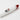 Angled close-up of the Daily High Club x Chong's Choice "Fat Steamroller" showing a glossy white glass body with a red mouthpiece and a small character logo on a white background.