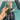 A hand holds The Bubblah, showcasing the curved glass form against a muted green backdrop.