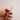 Close-up view of the StashLight - Doob Tube & Refillable Lighter held in a hand, showing its metallic finish and illuminated tip.